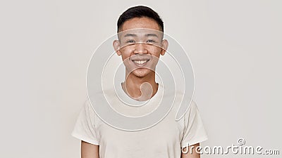 Smile. Portrait of young asian man with clean shaven face smiling at camera isolated over white background. Beauty Stock Photo