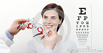 smile woman doing eyesight measurement with trial frame and visual test chart on white Stock Photo