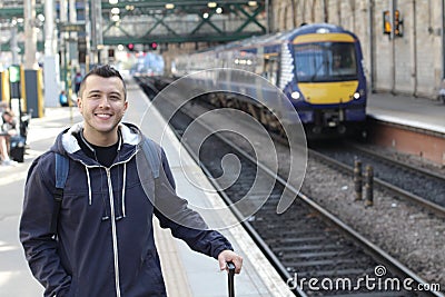 Smiley ethnic male waiting for a train Stock Photo