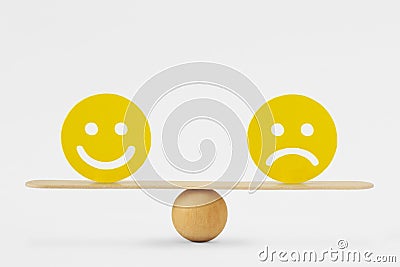 Smiley face and sad face on scale - Concept of balance between happiness and sadness Stock Photo