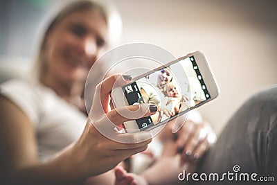 Smiley mother with her baby boy at home taking self portrait. Stock Photo