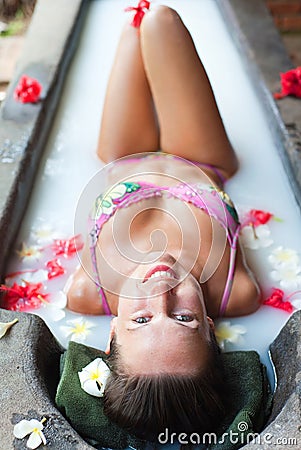 Smiley woman taking pleasure in milk bath Stock Photo