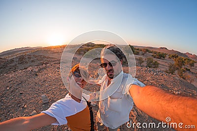 Smiling adult couple taking selfie in the Namib desert, Namib Naukluft National Park, main travel destination in Namibia, Africa. Stock Photo