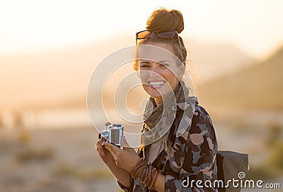 Smiling adventure tourist woman with retro photo camera Stock Photo