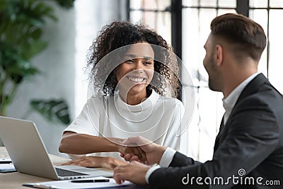 Smiling African American businesswoman shaking client hand at meeting Stock Photo