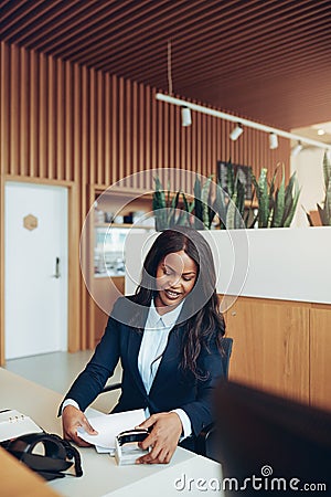 Smiling African American businesswoman sorting documents at a re Stock Photo