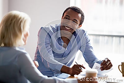 Smiling african american manager talking with client at business meeting Stock Photo