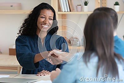 Smiling African American woman handshake couple clients Stock Photo