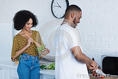 Smiling african american woman mixing salad Stock Photo