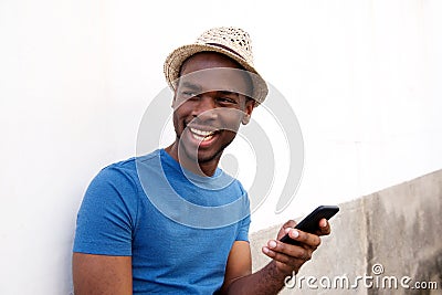 Smiling african american young man holding cellphone Stock Photo