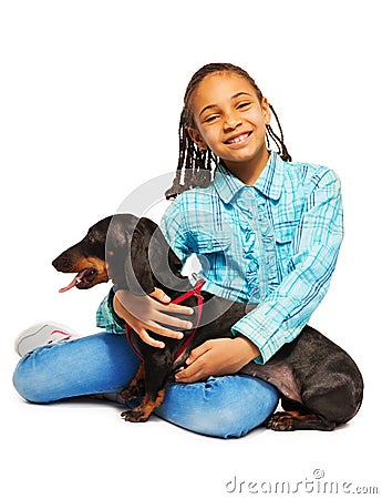 Smiling African girl hugging black dachshund Stock Photo