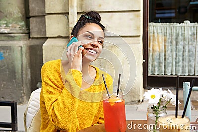 Smiling african woman at coffeeshop making phone call Stock Photo