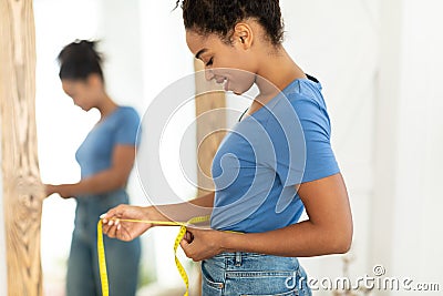 Smiling African Woman Measuring Waist After Slimming Standing At Home Stock Photo