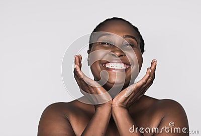 Smiling African woman with perfect skin against a gray background Stock Photo