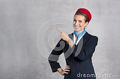 Smiling air hostess showing Stock Photo