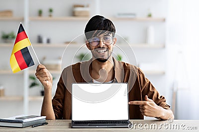 Smiling arab guy student showing flag of Germany and laptop Stock Photo