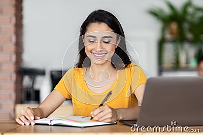 Smiling arab lady working online at cafe Stock Photo