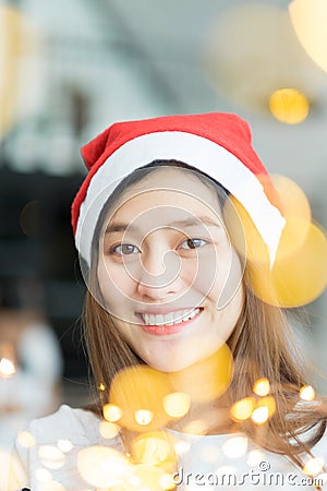 Smiling asia woman wear santa hat holding party string lights wi Stock Photo