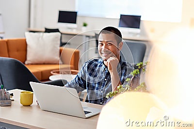 Smiling Asian architect at work in a modern office Stock Photo
