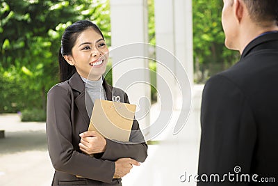 Smiling asian business woman while talking to her business partn Stock Photo