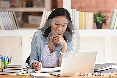 Smiling asian girl student study in library with laptop books Stock Photo