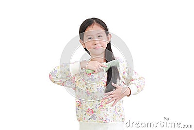 Smiling asian little kid girl combing long hair on white. Hair care concept Stock Photo