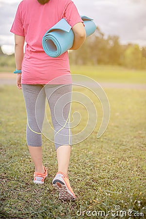 Smiling of Asian woman athlete an exercise and stretching in a field. Stock Photo
