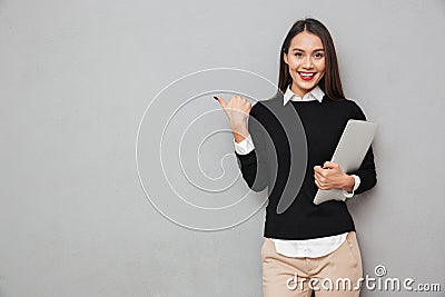 Smiling asian woman in business clothes holding laptop computer Stock Photo