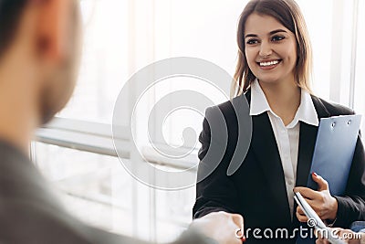 Smiling attractive businesswoman handshaking with businessman after pleasant talk, good relationships. Business concept photo Stock Photo