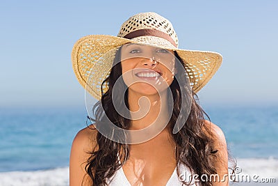 Smiling attractive dark haired woman wearing straw hat posing Stock Photo