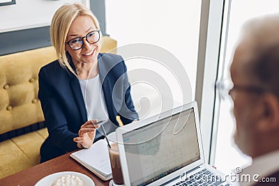 Smiling awesome blond woman explaining her business idea Stock Photo