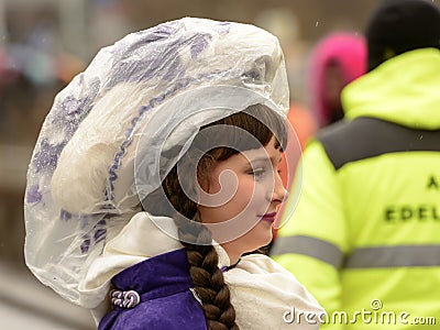 smiling baby majorette wrapped up against rain at Carnival parade, Stuttgart Editorial Stock Photo