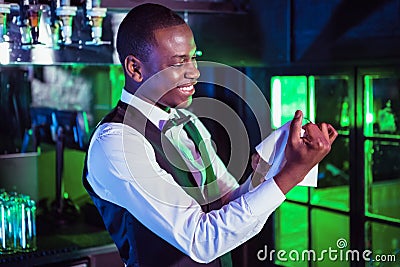 Smiling bartender cleaning a glass Stock Photo