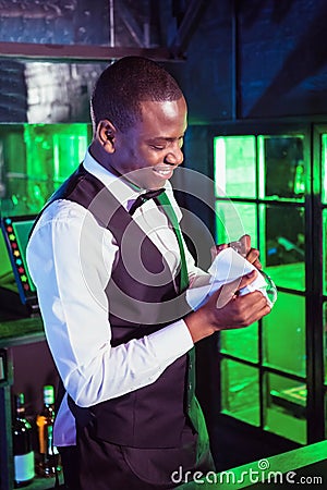 Smiling bartender cleaning a glass Stock Photo