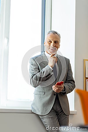 Smiling beaming senior man with wide smile deciding something Stock Photo