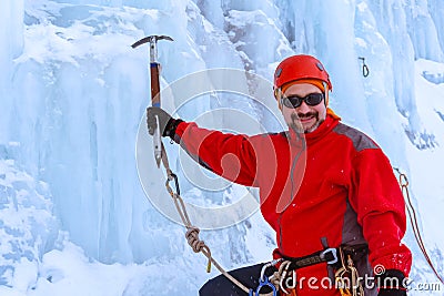 Positive climber with ice ax on glacier background Stock Photo