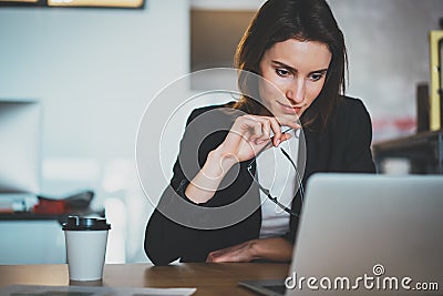 Smiling beautiful businesswoman using laptop computer at modern office.Blurred background.Horizontal. Stock Photo