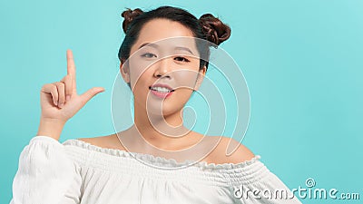Smiling beautiful woman having an idea close up face pointing up with finger Stock Photo
