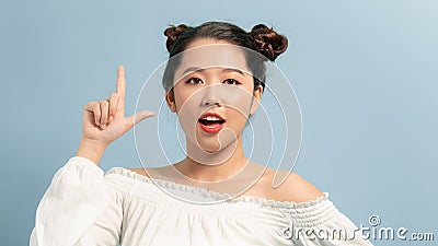Smiling beautiful woman having an idea close up face pointing up with finger Stock Photo