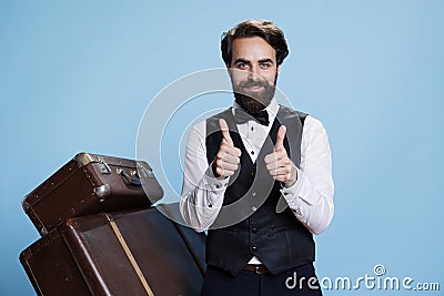 Smiling bellboy does thumbs up sign Stock Photo