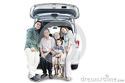 Smiling big family sitting on the car trunk Stock Photo
