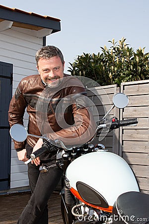 Smiling biker hipster portrait handsome man aside motorcycle neoretro classic bike Stock Photo