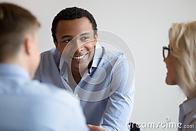 Smiling black businessman talk with colleagues at office meeting Stock Photo