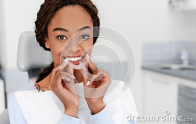 Smiling black girl holding invisible aligner, modern teeth trainer Stock Photo