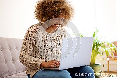 Smiling black woman using laptop computer at home Stock Photo