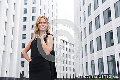 Smiling blond business woman with red lipstick on urban background Stock Photo