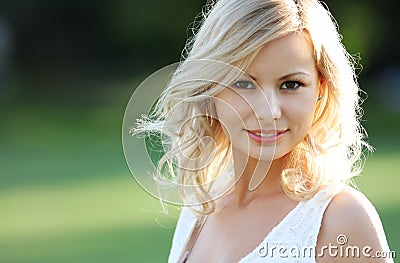 Smiling blonde girl. Portrait of happy cheerful beautiful young woman, outdoors. Stock Photo