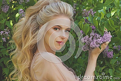 Smiling blonde woman. Lovely young lady feeling happy in the summer park Stock Photo