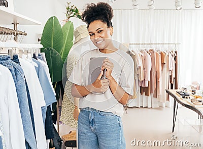 Smiling boutique owner holding digital tablet and looking at camera Stock Photo