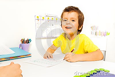 Smiling boy draws with pencil on the paper Stock Photo